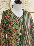 A green printed ethnic kurta with a matching dupatta draped over a white mannequin torso. The kurta features a vibrant floral and paisley pattern in pink, yellow, and orange, with a decorative embroidered neckline.